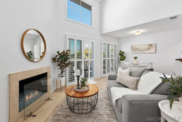 a living room with furniture a fireplace and a large window