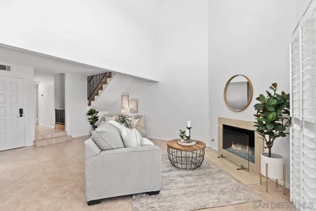 a living room with furniture a fireplace and a potted plant