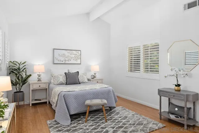 a bedroom with a bed a potted plant and a window