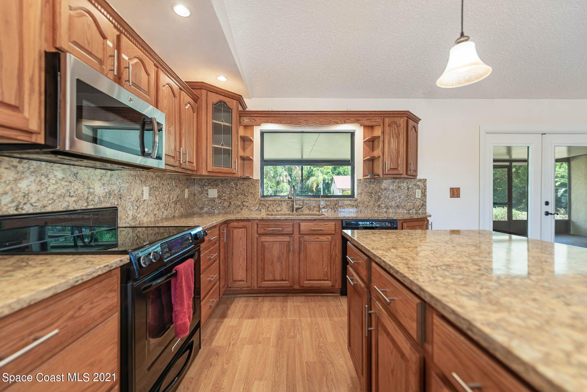 3330 Grant Line Road Mims, FL 32754 - Photo 14 of 42 a kitchen with stainless steel appliances granite countertop a sink and a stove