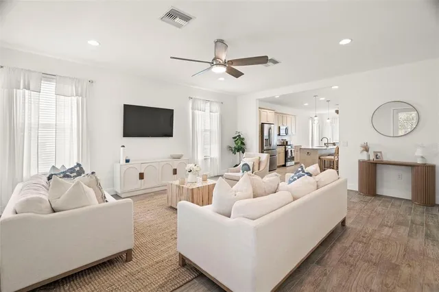 a kitchen with stainless steel appliances granite countertop a sink a stove a refrigerator cabinets and chairs