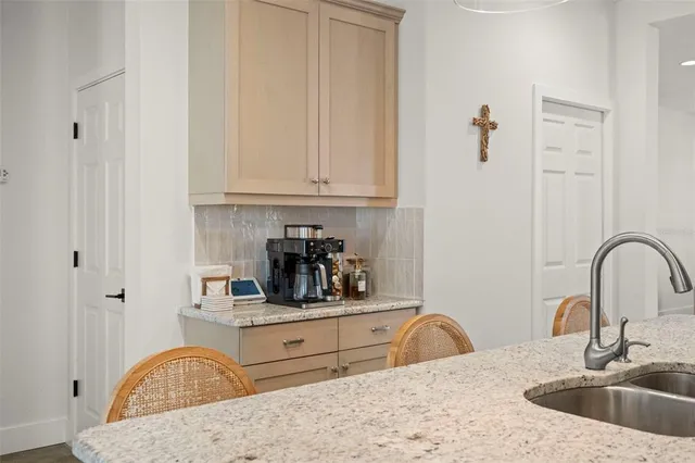 a kitchen with granite countertop a sink a stove and cabinets