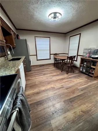 a kitchen with stainless steel appliances wooden floors and wooden cabinets