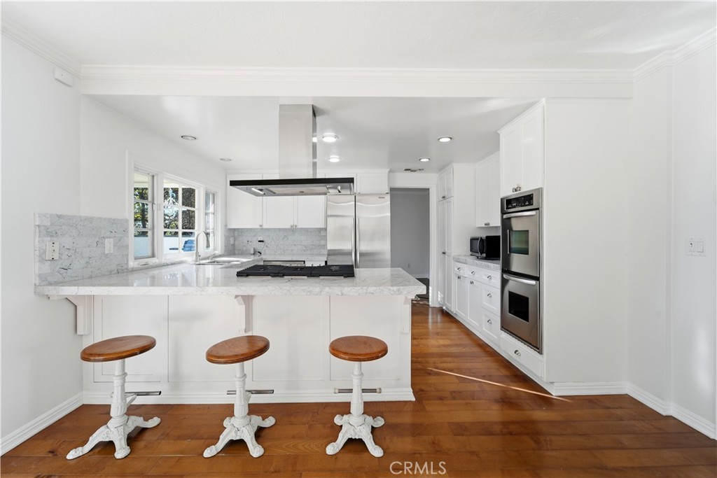 11344 Baird Avenue Porter Ranch, CA 91326 - Photo 11 of 45 a kitchen with stainless steel appliances granite countertop a stove and white cabinets