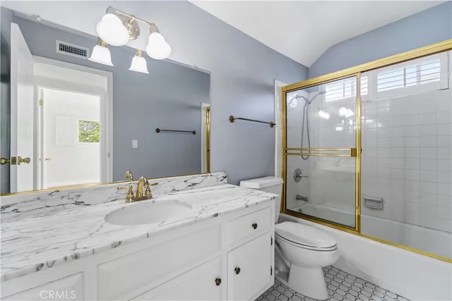 a bathroom with a double vanity sink toilet and shower
