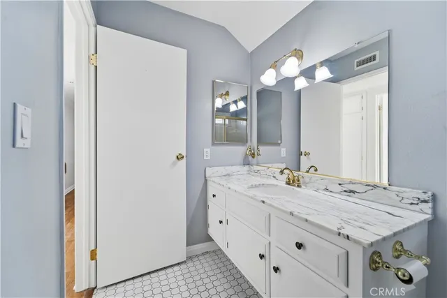 a bathroom with a granite countertop sink and a mirror