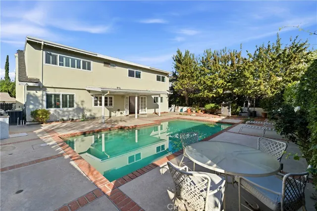 a view of a house with backyard and sitting area