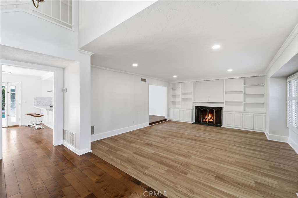 11344 Baird Avenue Porter Ranch, CA 91326 - Photo 5 of 45 a view of an empty room with wooden floor a fireplace and a window