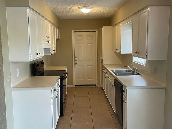 a kitchen that has a sink and a stove in it