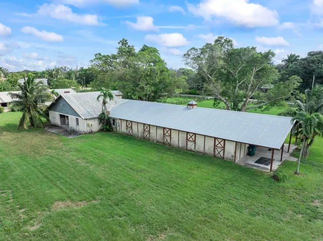 a view of a house with a big yard and large trees