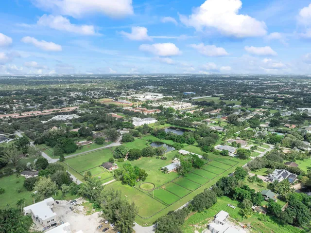 an aerial view of residential houses with outdoor space and trees