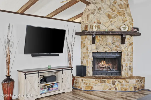 a living room with a fireplace a flat screen tv and a fireplace