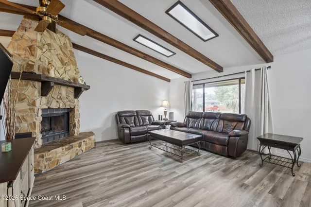 a living room with furniture a fireplace and a flat screen tv