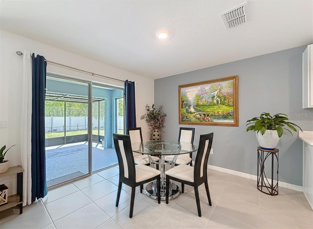 13677 Southwest 69th Terrace Ocala, FL 34473 - Photo 11 of 28 a dining room with furniture and potted plants