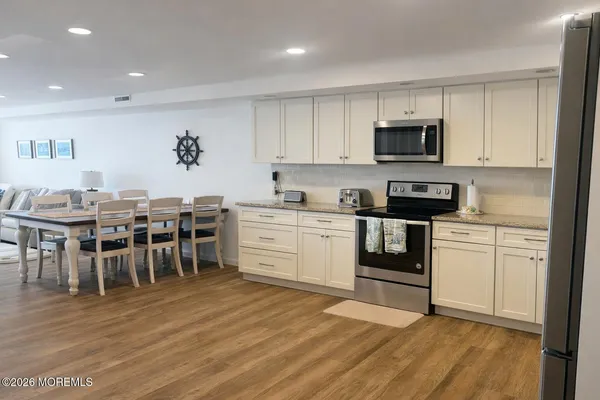 a kitchen with stainless steel appliances granite countertop a refrigerator sink and white cabinets