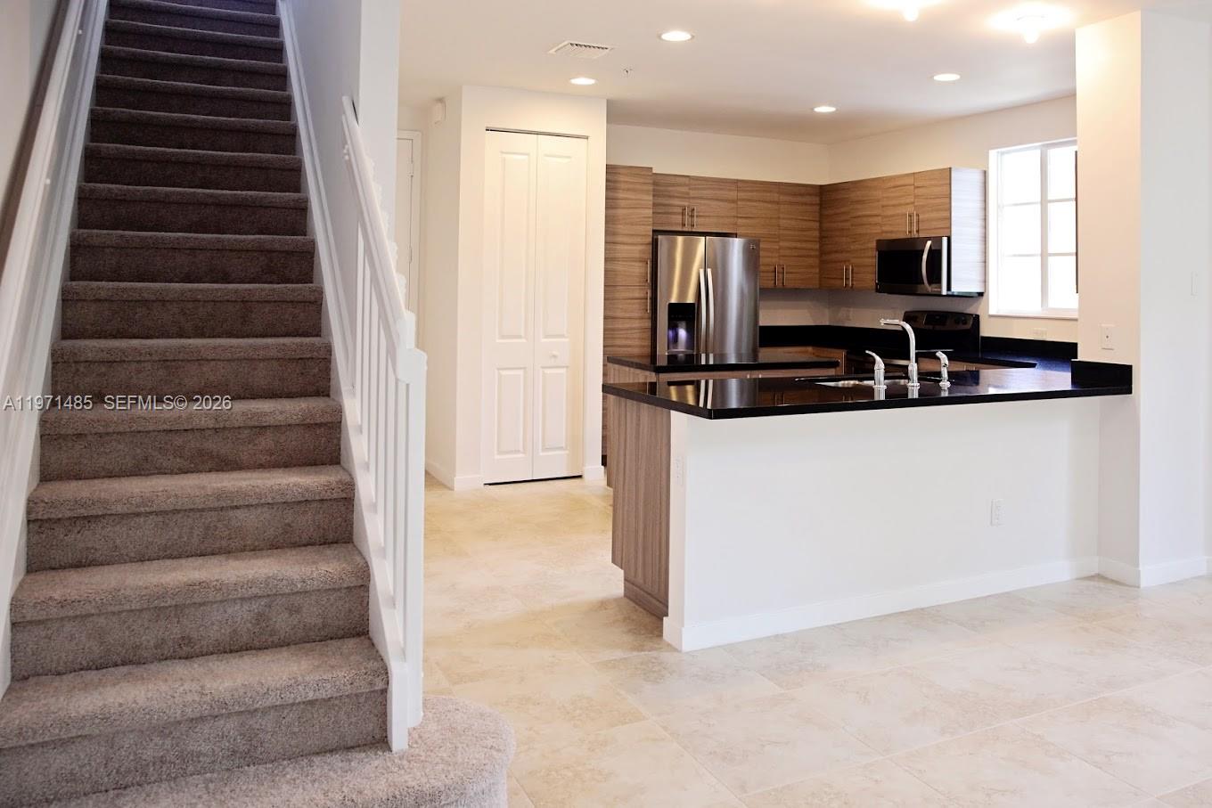 2844 Southwest 81st Terrace, Unit 2840 Miramar, FL 33025 - Photo 3 of 10 a view of a kitchen with stainless steel appliances kitchen island granite countertop a stove and a sink