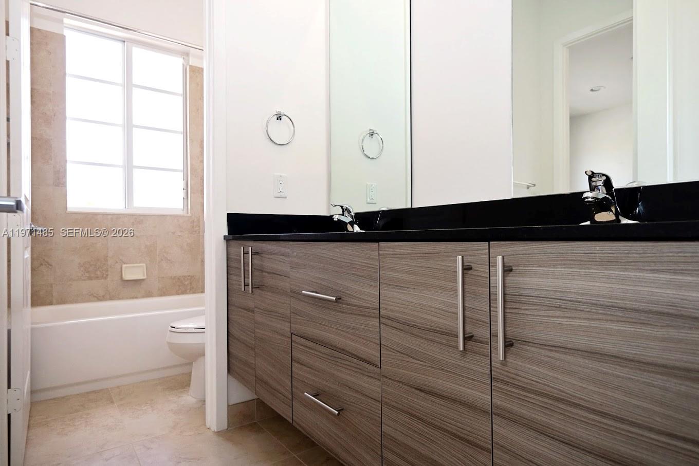 2844 Southwest 81st Terrace, Unit 2840 Miramar, FL 33025 - Photo 5 of 10 a bathroom with a granite countertop sink a toilet and bathtub