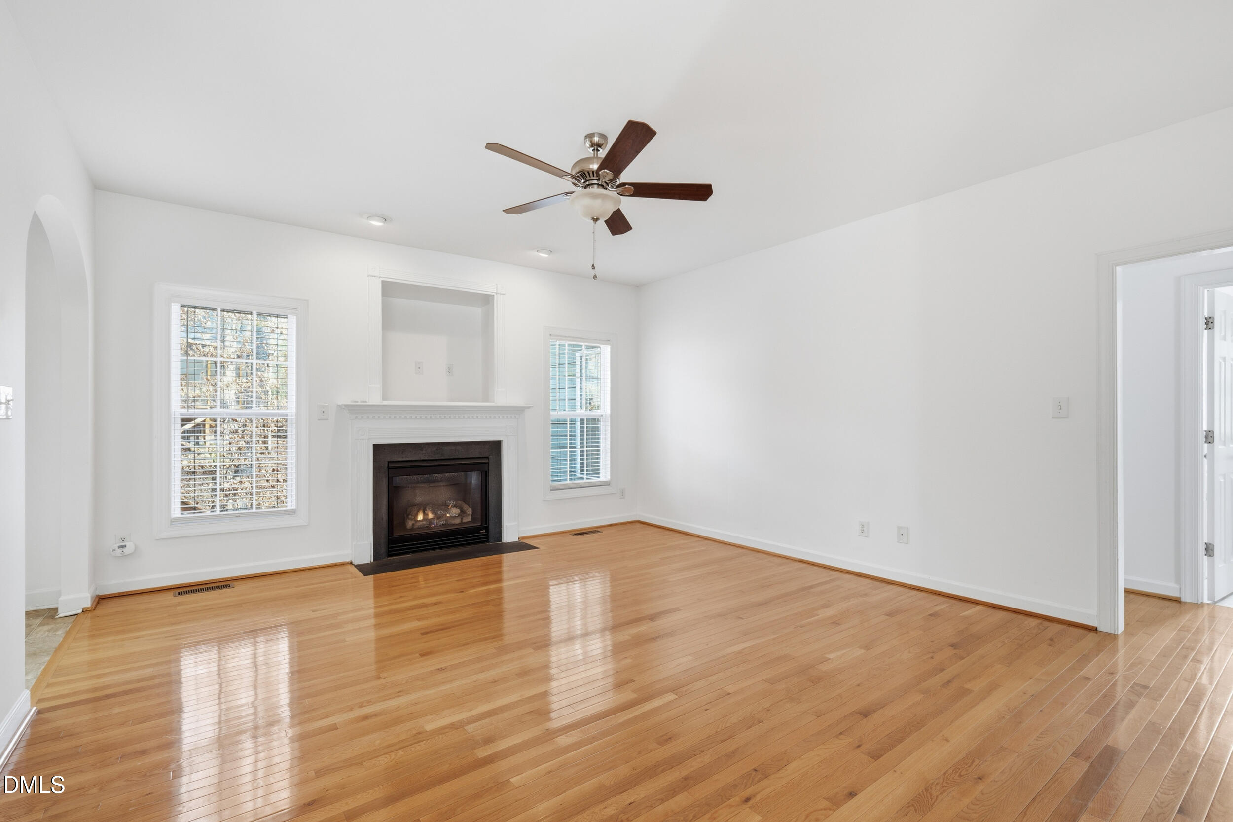 66 Bellemont Road Pittsboro, NC 27312 - Photo 4 of 33 an empty room with windows fireplace and a ceiling fan