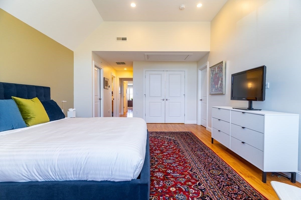 1 South Cottage Road, Unit 1 Belmont, MA 02478 - Photo 24 of 35 a bedroom with a bed and a flat screen tv