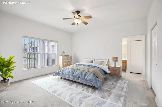 a bedroom with a large bed chandelier and a window