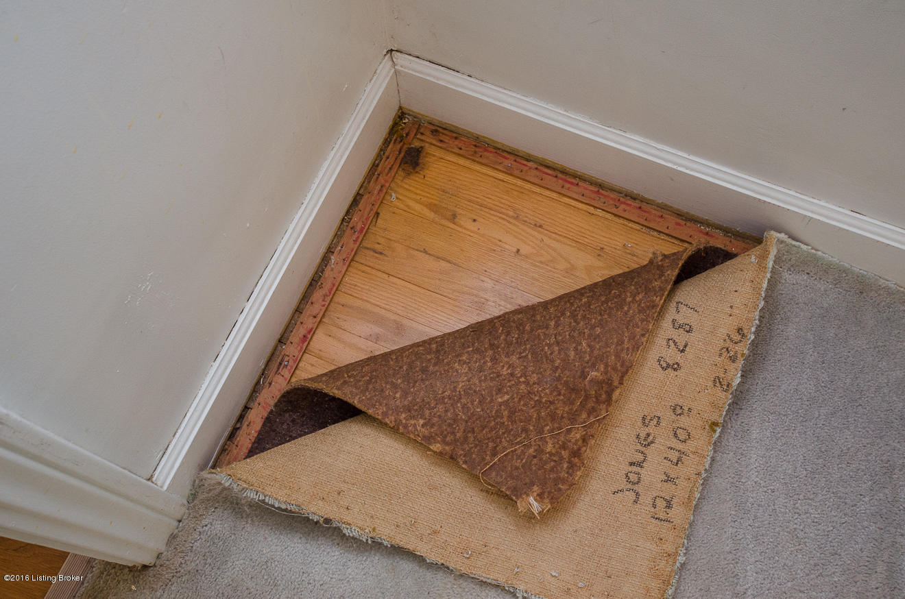 Hardwood is in all three bedrooms and is found underneath the carpet in one corner of the dining room.