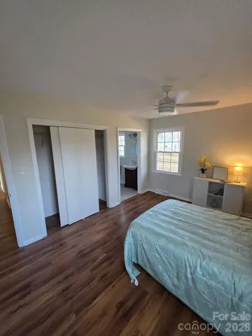 a bedroom with a large bed and wooden floor
