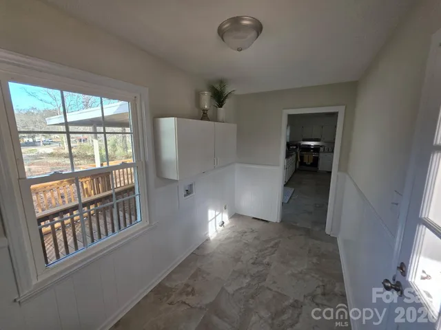 a view of a livingroom with furniture staircase and windows