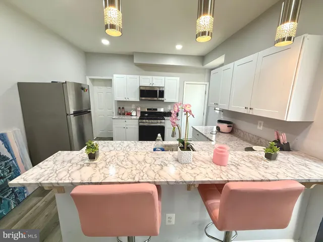 a kitchen with stainless steel appliances granite countertop a sink refrigerator and microwave