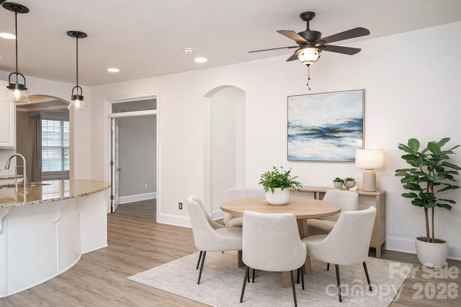 7900 Honey Fig Road Charlotte, NC 28277 - Photo 18 of 48 a dining room with furniture potted plants and wooden floor
