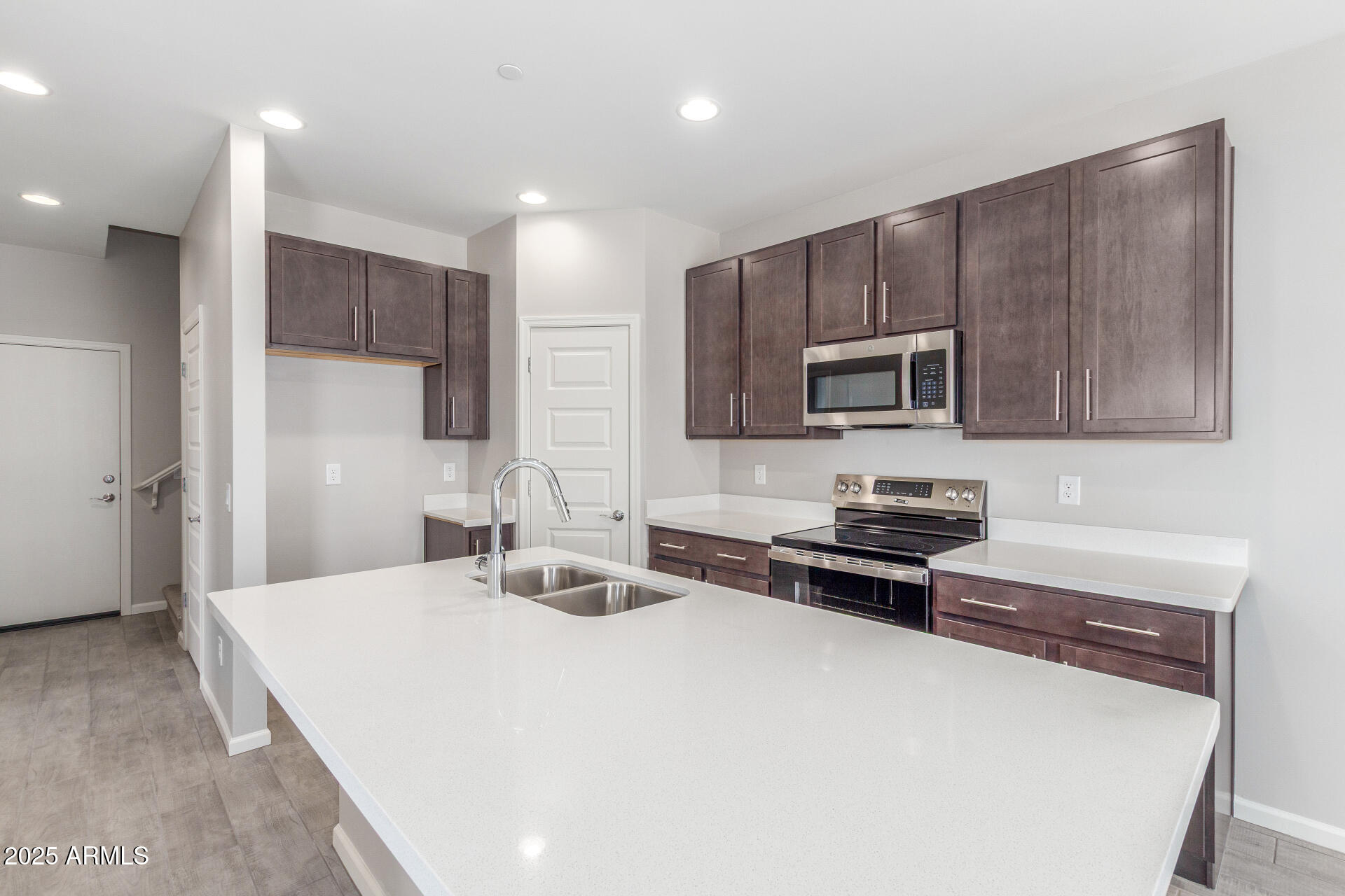 733 East Commonwealth Avenue, Unit 29 Chandler, AZ 85225 - Photo 4 of 37 a kitchen with granite countertop a stove a sink and a microwave