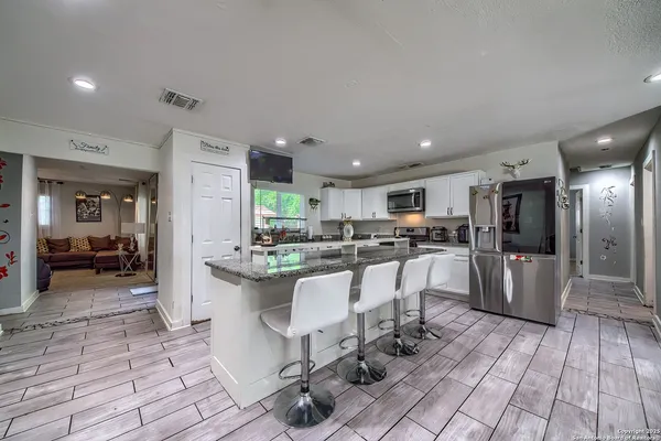 a kitchen with a sink and chairs
