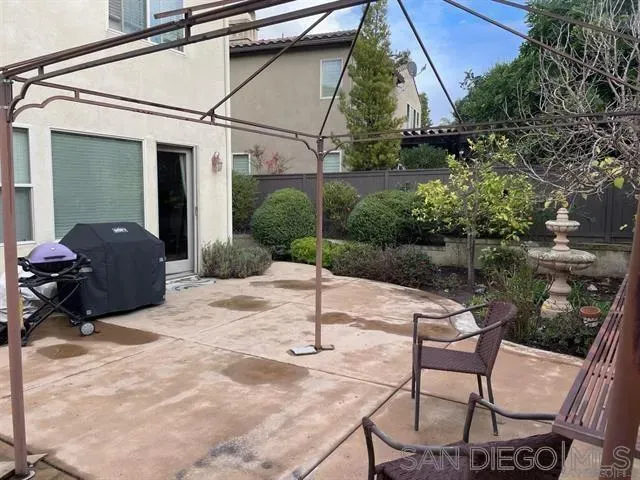 a view of a chair and table in backyard of the house
