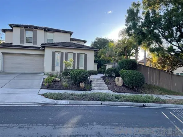a front view of a house with garage and plants