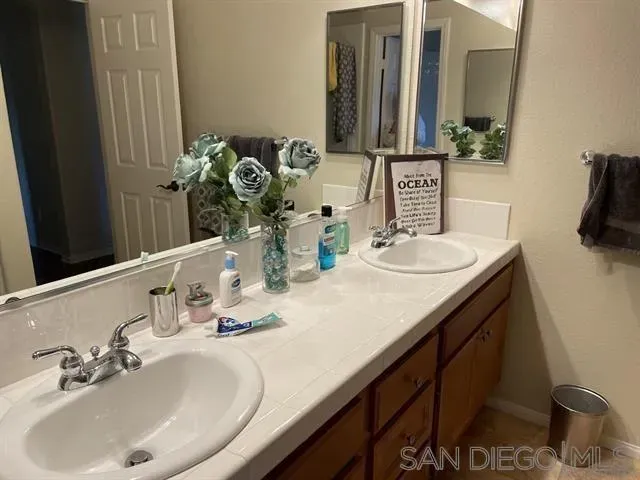 a bathroom with double vanity sinks and a mirror