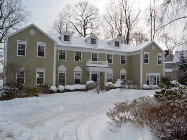 a front view of house with yard and trees around