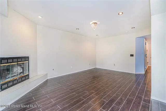 a view of empty room with wooden floor and fireplace