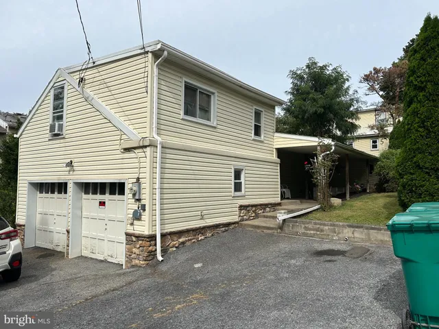 a view of a white house with a yard and garage