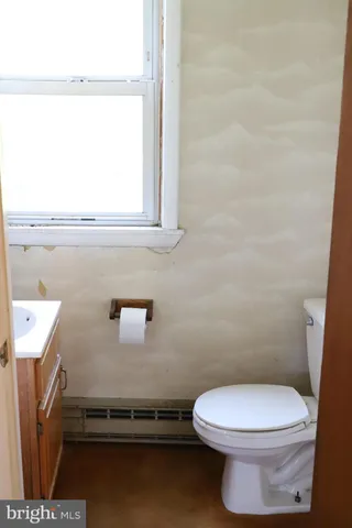 a bathroom with a toilet a sink and a window