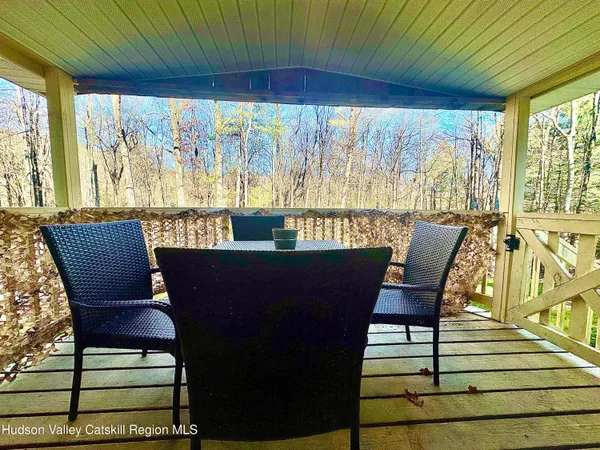 a view of a porch with furniture and wooden floor