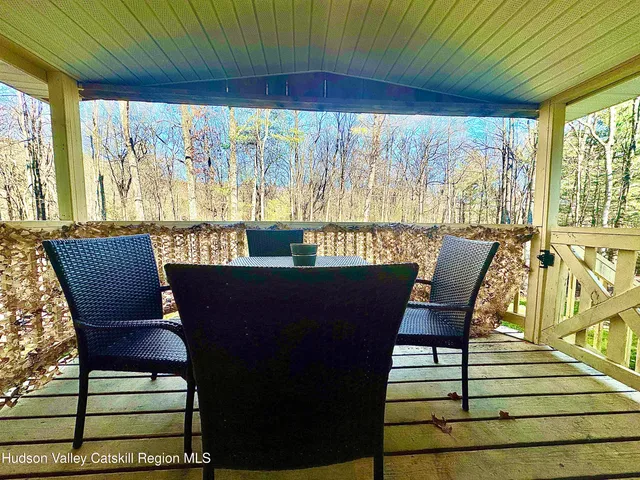 a view of a porch with furniture and wooden floor