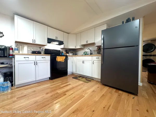 a kitchen with stainless steel appliances granite countertop a refrigerator sink stove and white cabinets