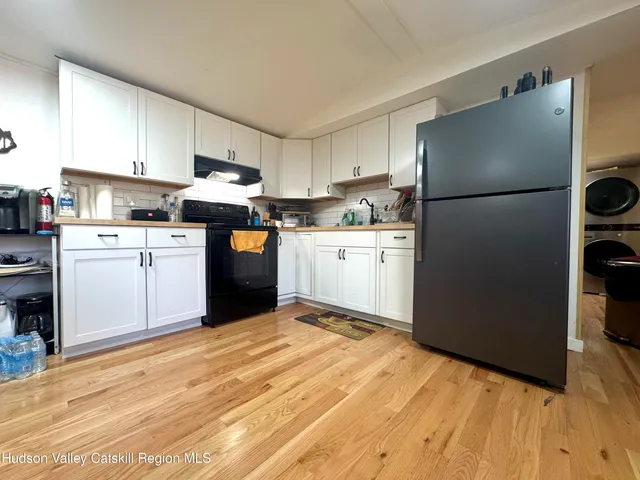 a kitchen with stainless steel appliances granite countertop a refrigerator sink stove and white cabinets