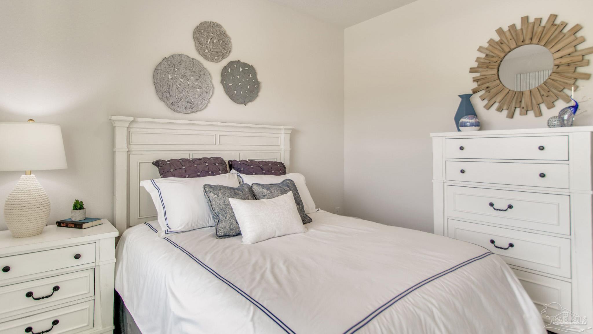 108 Albatross Street Cantonment, FL 32533 - Photo 28 of 35 a bedroom with a bed and cabinets