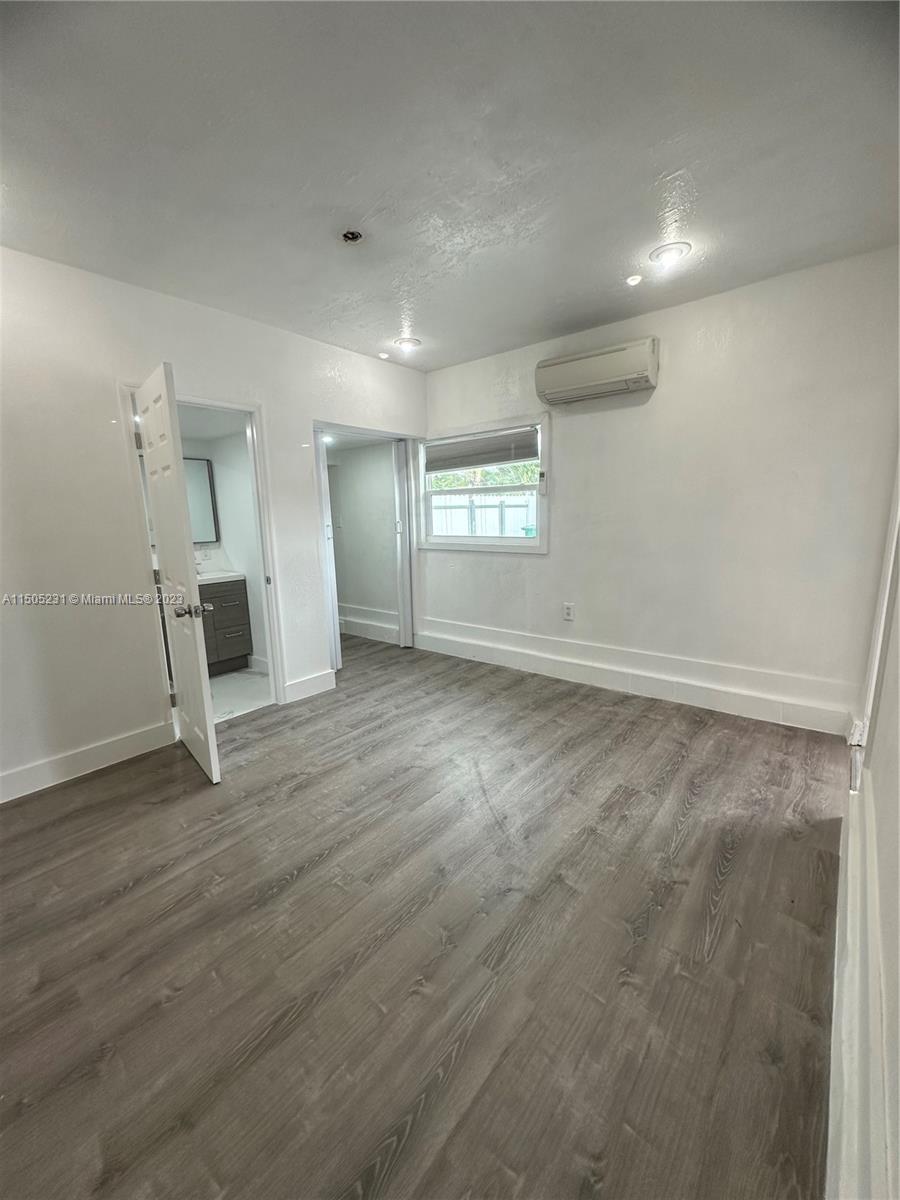 an empty room with wooden floor and white walls
