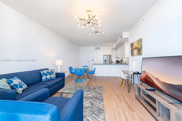 a living room with furniture and a chandelier
