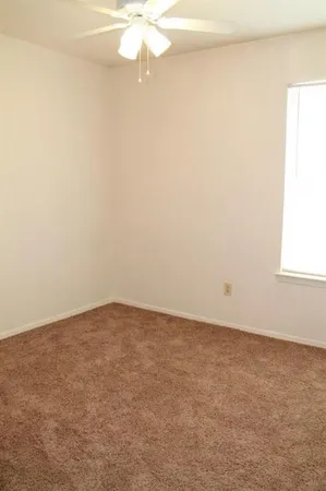 an empty room with a chandelier fan