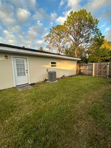 a view of a backyard with plants and large tree