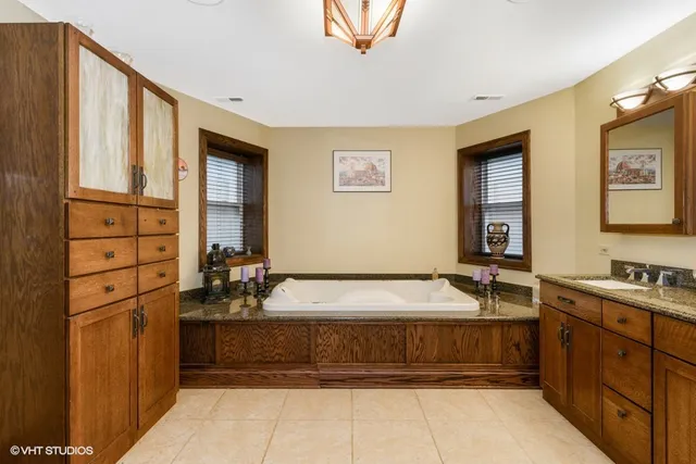 a spacious bathroom with a tub sink and mirror