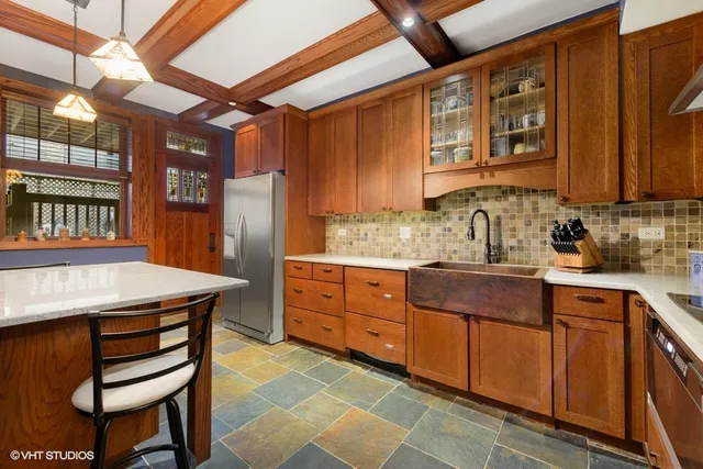 a kitchen with stainless steel appliances kitchen island granite countertop a table chairs in it and wooden floors