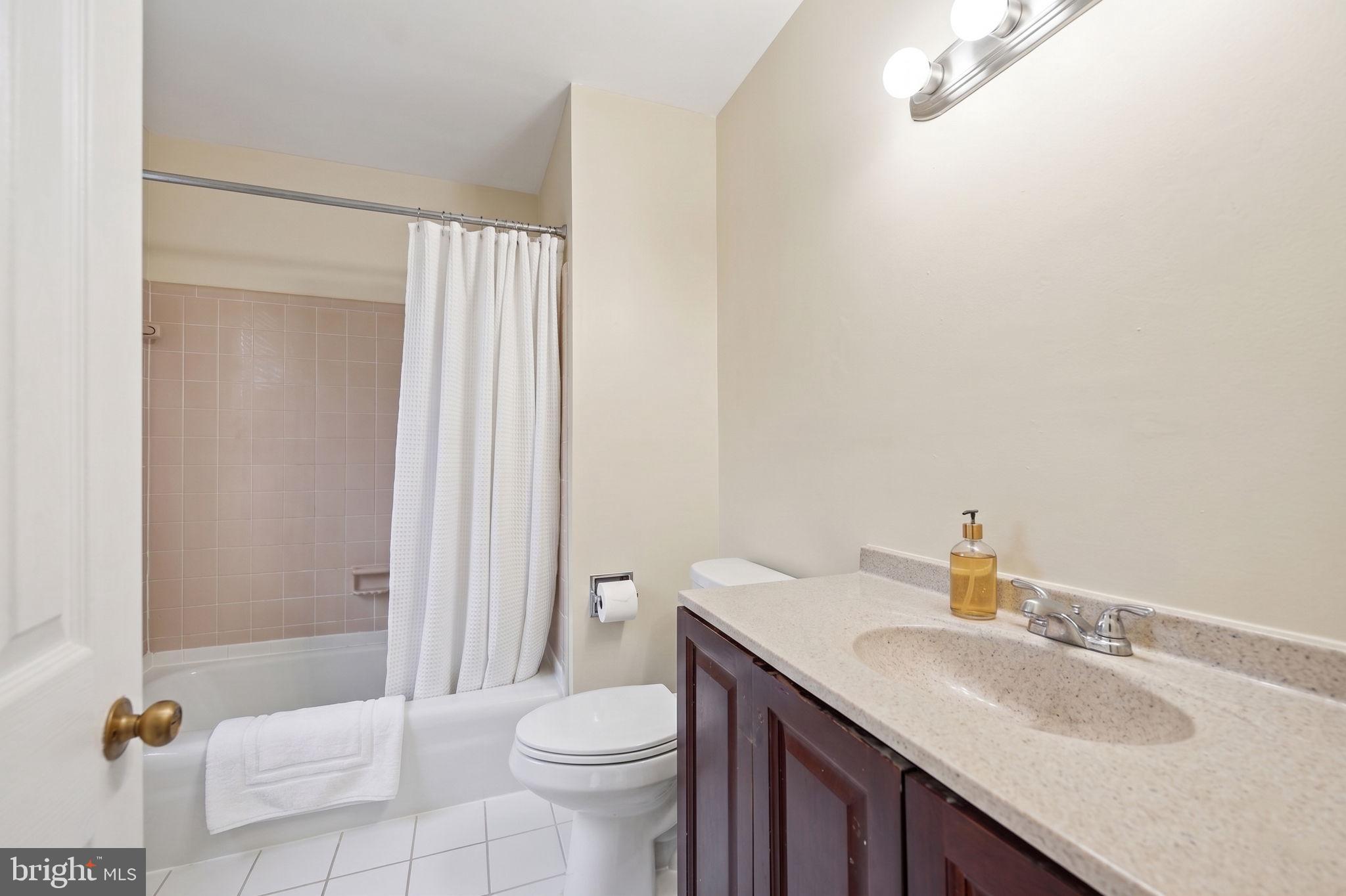 8260 Getty Court Springfield, VA 22153 - Photo 22 of 31 a bathroom with a granite countertop sink a toilet and shower